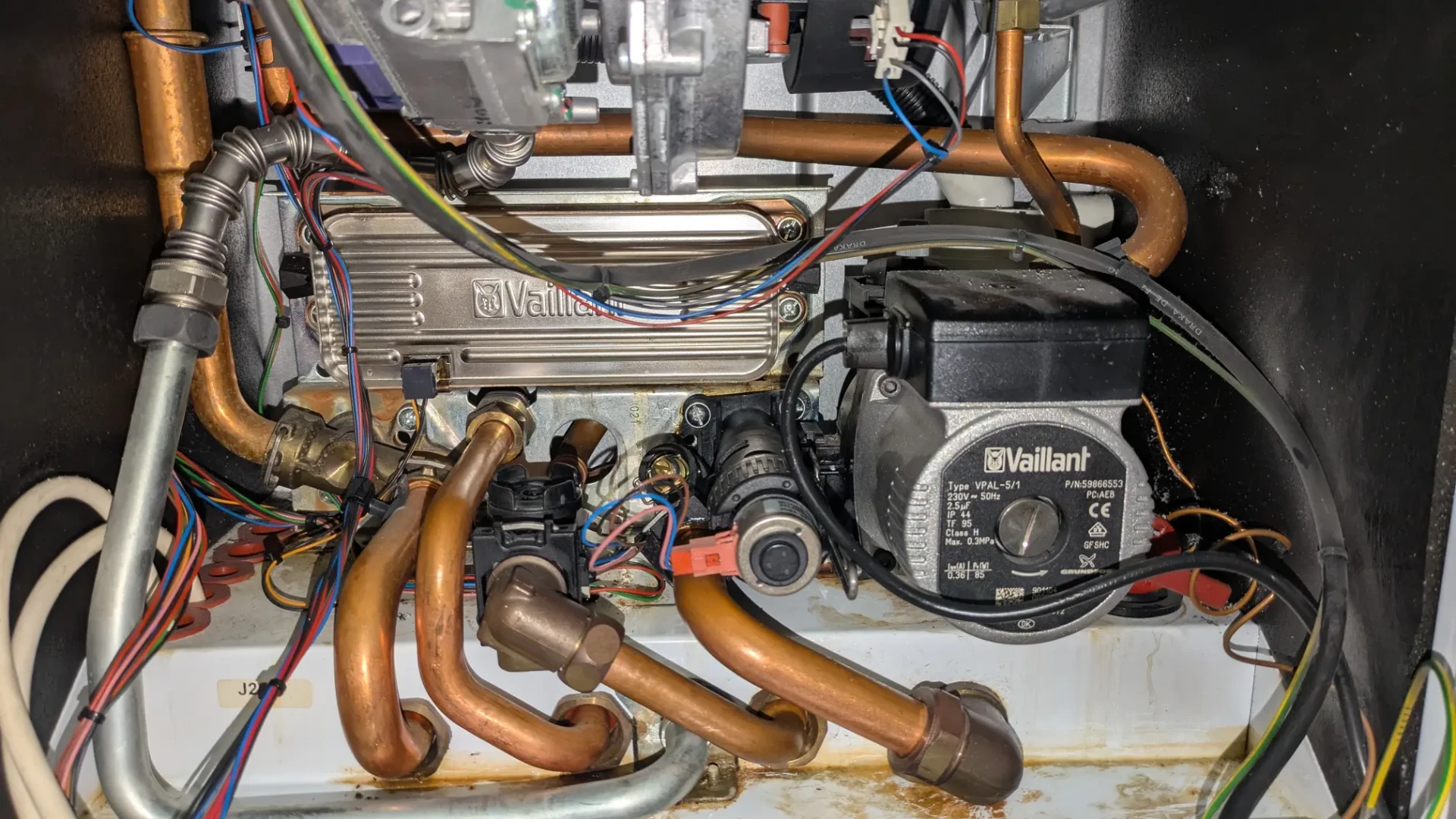 Heating engineer carrying out an annual boiler service and safety check in a domestic kitchen